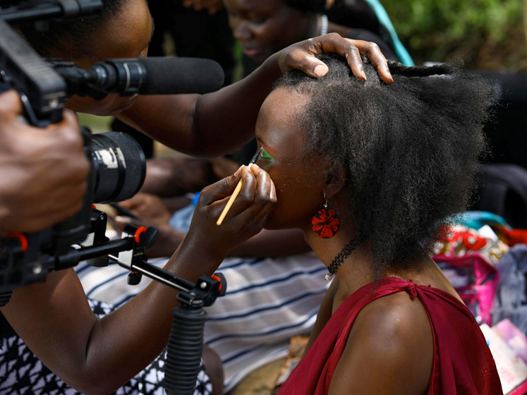 Woman getting makeup done in front of a camera